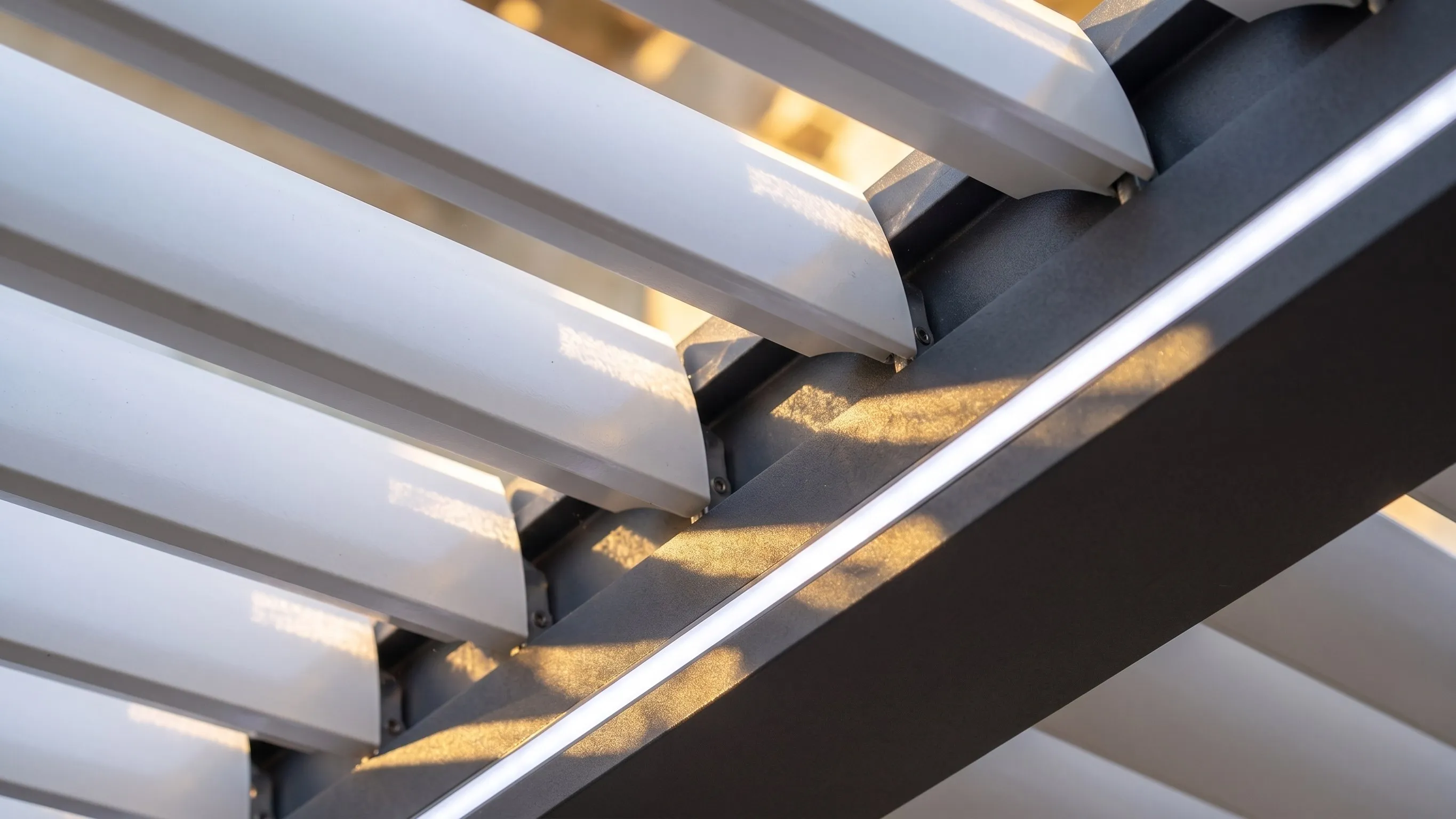 Détail des lames orientables en aluminium et du bandeau LED intégré, en lumière rasante